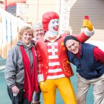 Volunteers from the Optimist Club take a picture with the Ronald statue in the courtyard.