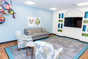 The Ronald McDonald Family Room at UAB sitting area includes two recliners and a couch set up around the TV.
