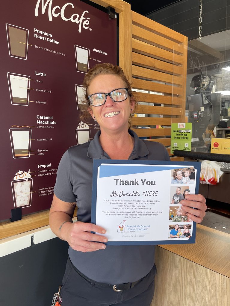 Woman wearing glasses holds up a thank you certificate