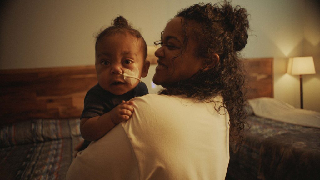 A mother holds her toddler son